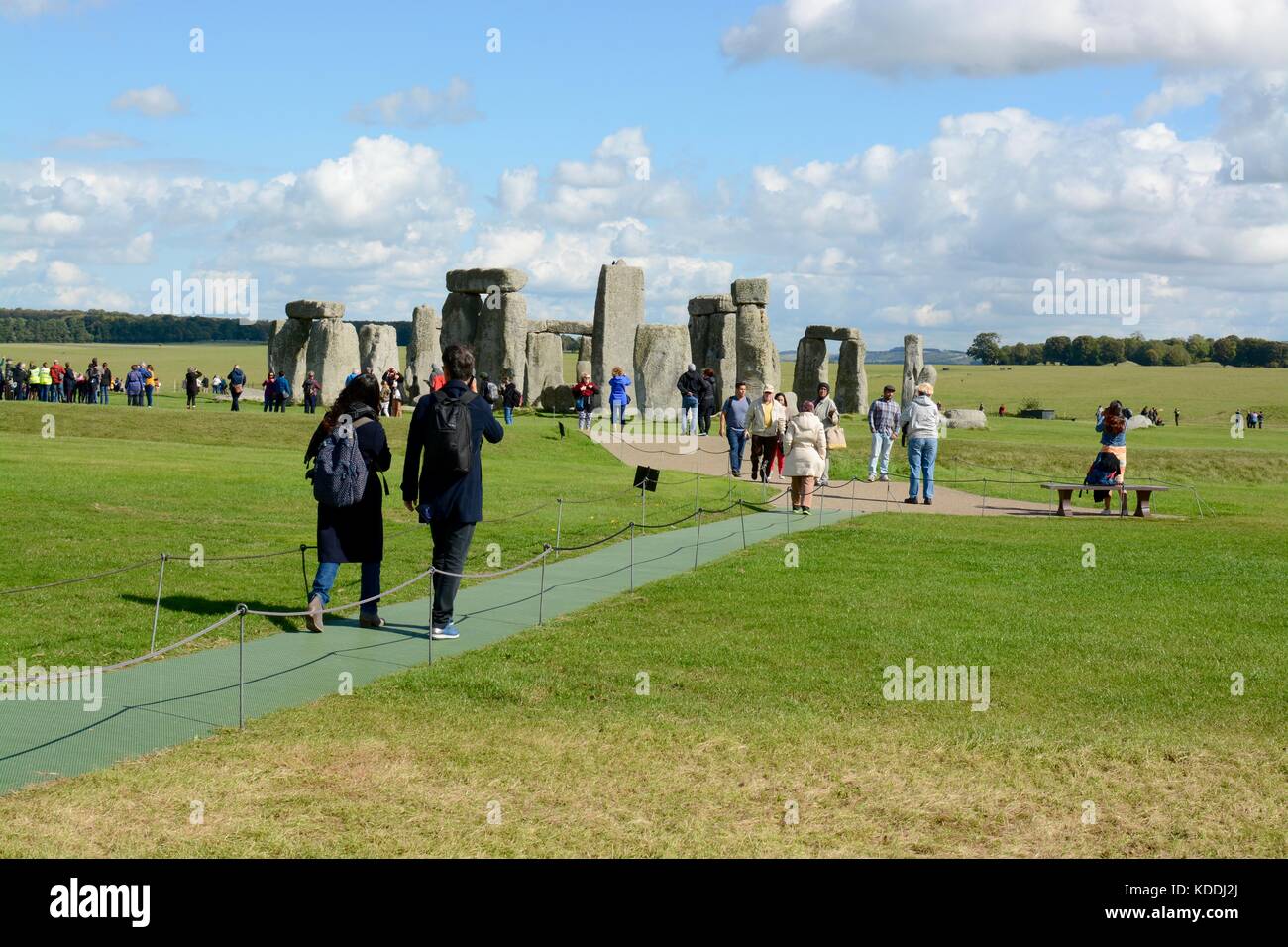 Besucher wandern zu Stonehenge, in der Nähe von Amesbury, Wiltshire, England, Großbritannien Stockfoto