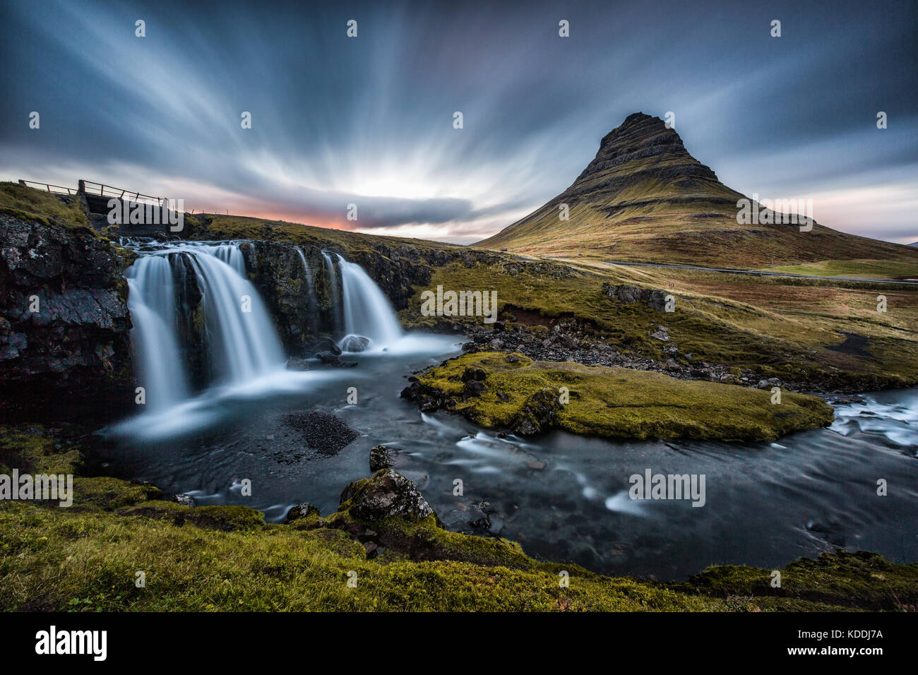 Kirkjufell Berg mit Kirkjufellfoss im Vordergrund mit langen Belichtungszeiten bei Sonnenuntergang, Halbinsel Snaefellsnes, Island Stockfoto