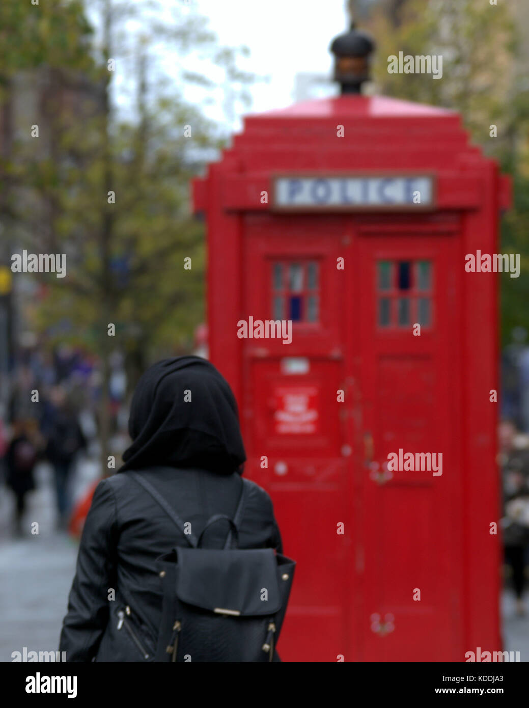 Kopftuch Schal muslimischen schwarzer Rucksack mit roten Polizei Box aus gesehen hinter Stockfoto