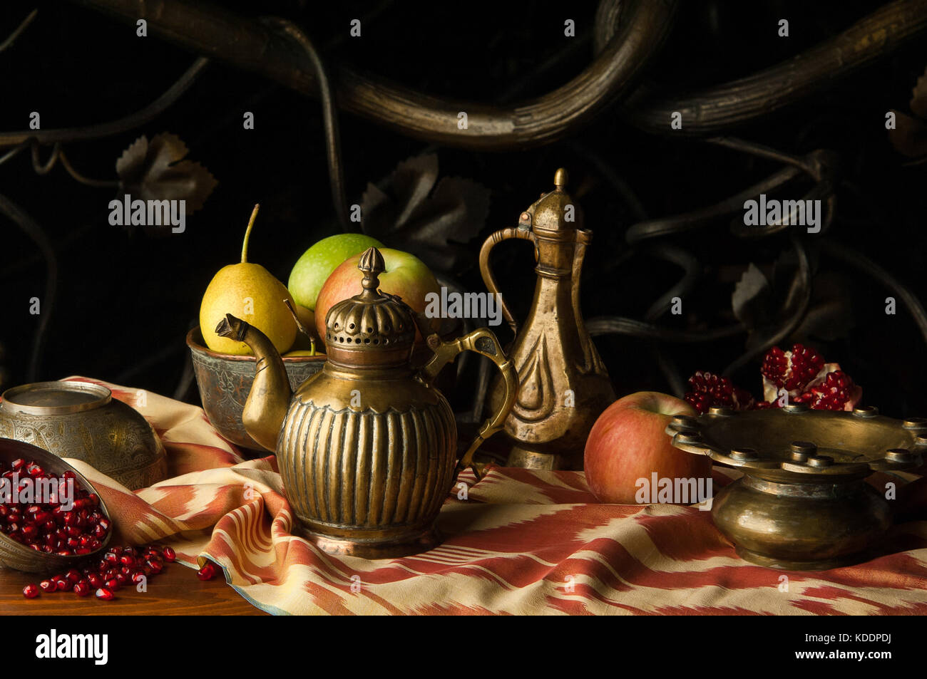 Obst und ein Metall Kanne mit Schüsseln im orientalischen Stil auf dem Hintergrund der dekorativen schmieden Ornament. Noch leben im orientalischen Stil Stockfoto