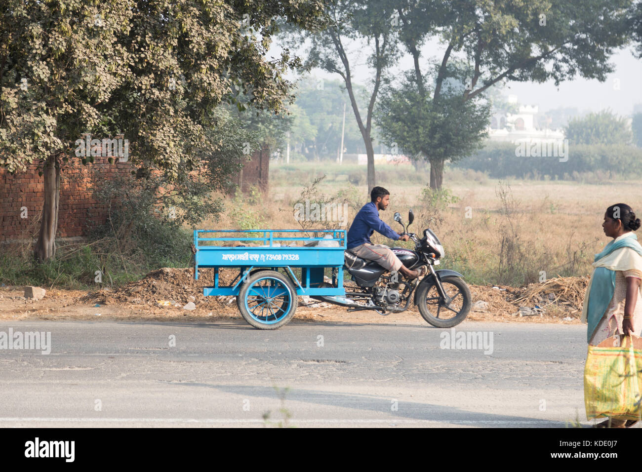 Shankar, panjab, Indien. 13. Oktober 2017. das Leben auf der Straße in Shankar, ländlichen indischen Dorf. Menschen in der morgendlichen Fahrt zur Schule und Arbeit. den Landwirten vor Ort ihre Ware durch Traktor. wenige Leute tragen Schutzhelme, so gibt es eine hohe Rate von Verletzungen und Unfällen Kredit: wansfordphoto/alamy leben Nachrichten Stockfoto