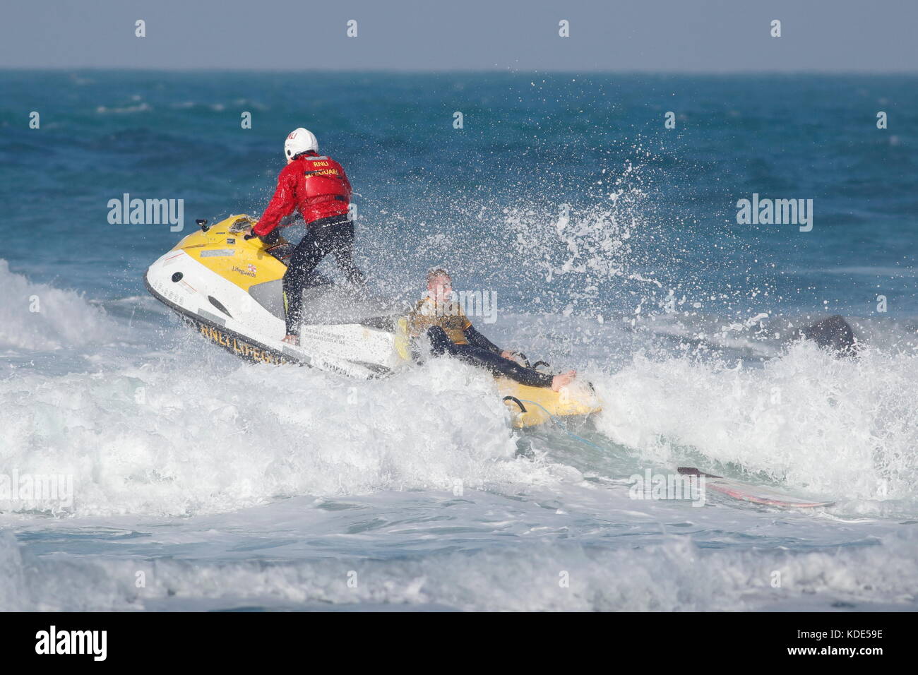 Fistral Beach, Newquay, Cornwall, England. 13. Oktober, 2017. Surfer nehmen an Tag 1 heizt der britischen Universität und Hochschule Sport Surfen Wettbewerb. Ein surfer wird von der RNLI vom Felsen geholfen, auf der Nordseite der Strand. Stockfoto