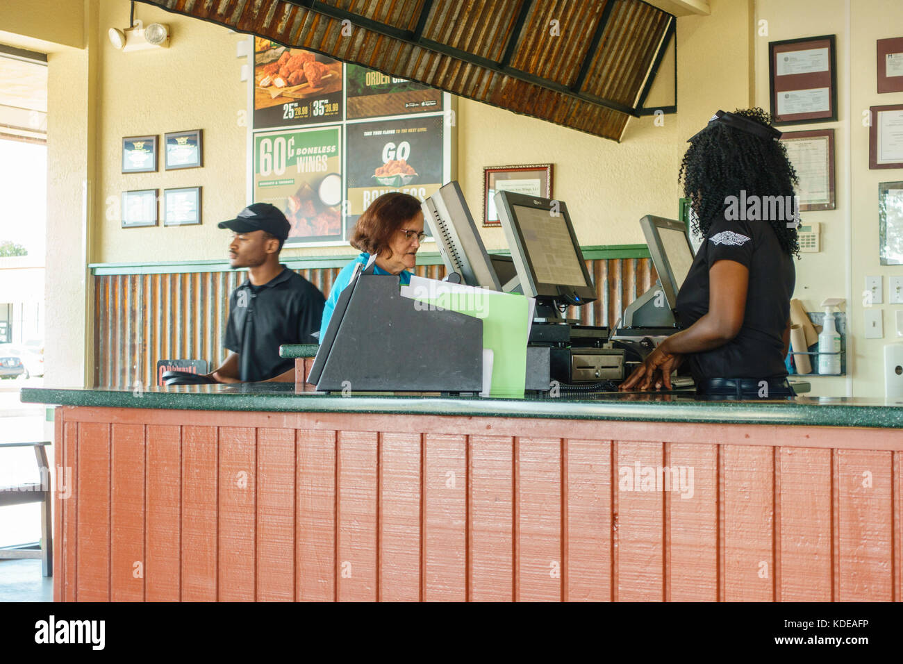 Ein Mitarbeiter mit einem Kunden am Flügel, ein Chicken Wing food Restaurant und eine Sportbar. Oklahoma City, Oklahoma, USA. Stockfoto