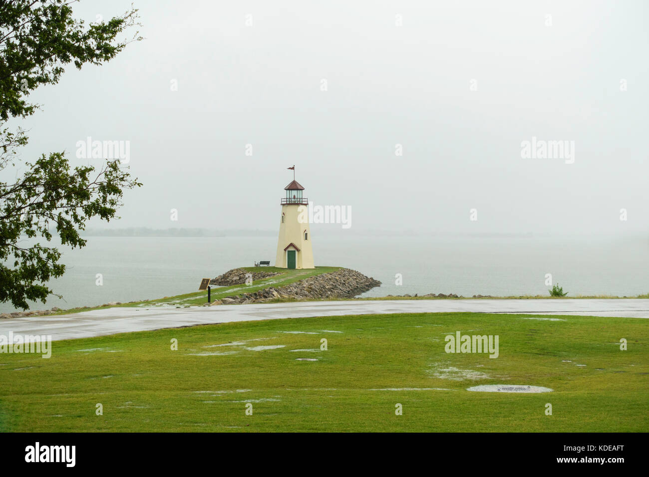 Der Leuchtturm am Ende eines Anlegesteges am Hefner Lake, Oklahoma City, Oklahoma, USA an einem regnerischen, nebeligen Tag. Stockfoto
