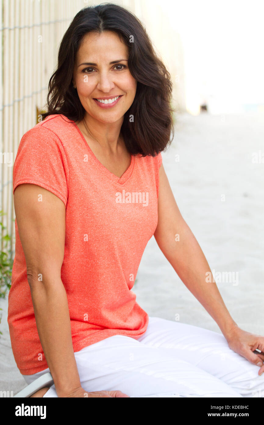 Schöne Hispanic Frau am Strand lächelnd. Stockfoto
