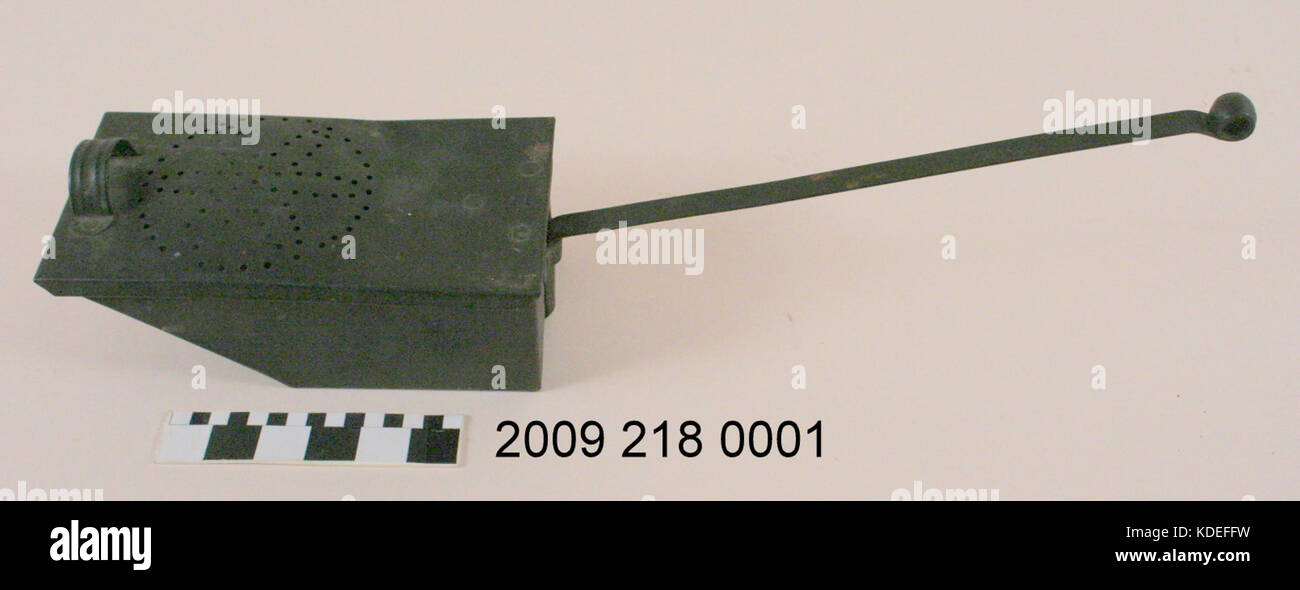 Metallgehäuse mit langer Griff für den Transport von heißen Kohlen Stockfoto