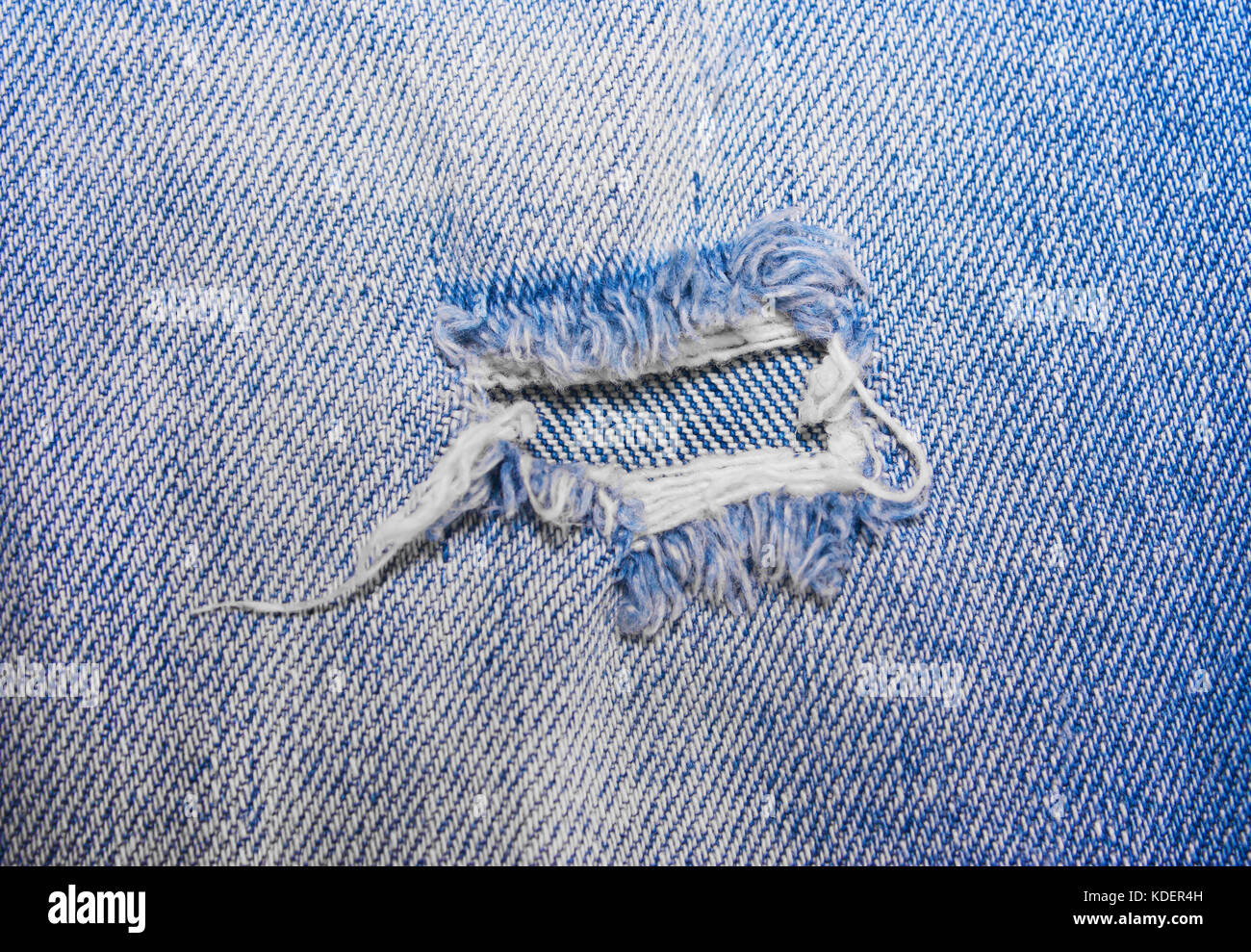 Die Bohrung an der blauen Jeans, Denim Textur Stockfoto