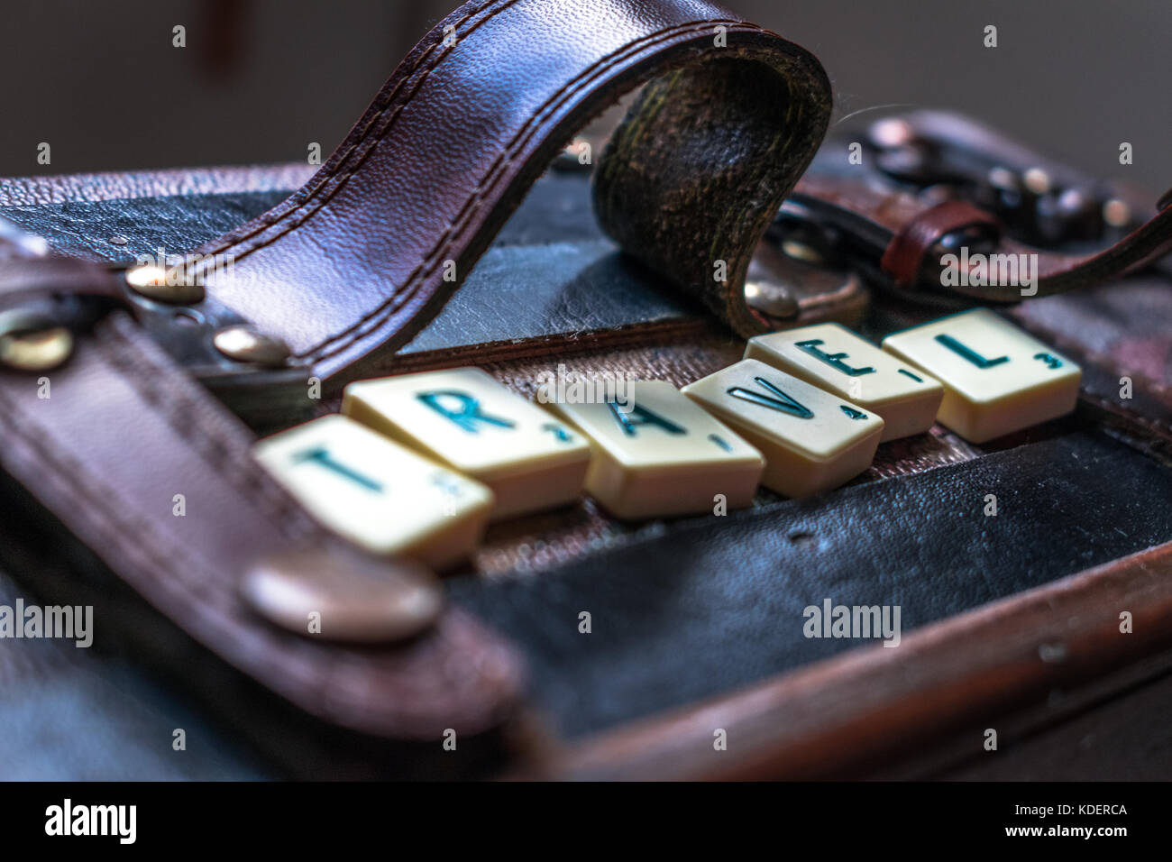 Reisen die Welt scrabble tiles Leder Koffer Hintergrund Stockfoto