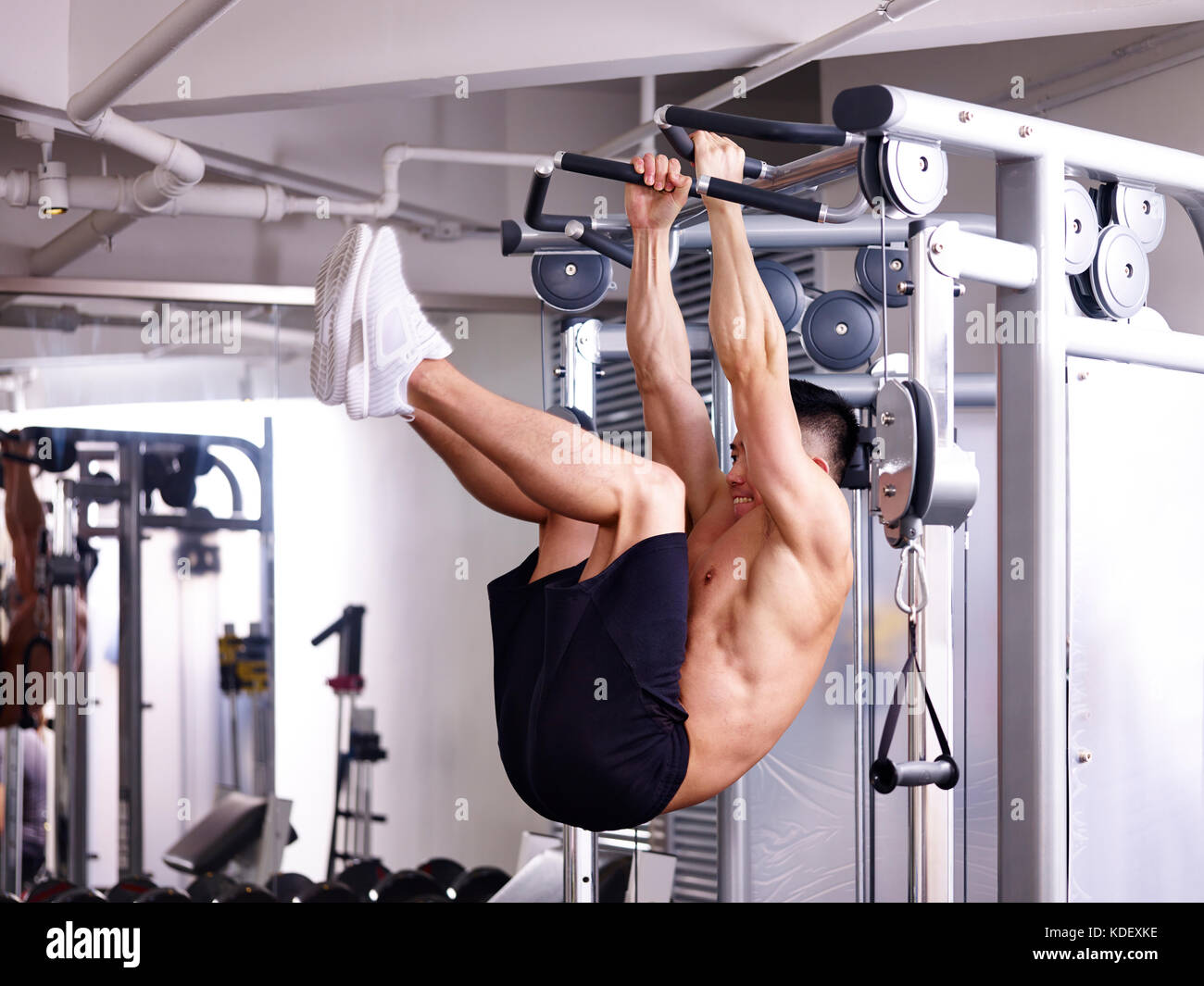 Asiatische Bodybuilder trainieren Bauchmuskeln selbst hängen von der Ausstattung. Stockfoto