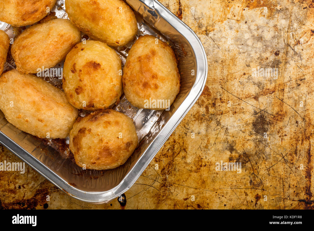 Bratkartoffeln in einem silbernen Backofen Backblech auf einem distressed Backblech mit Kopie Raum Stockfoto