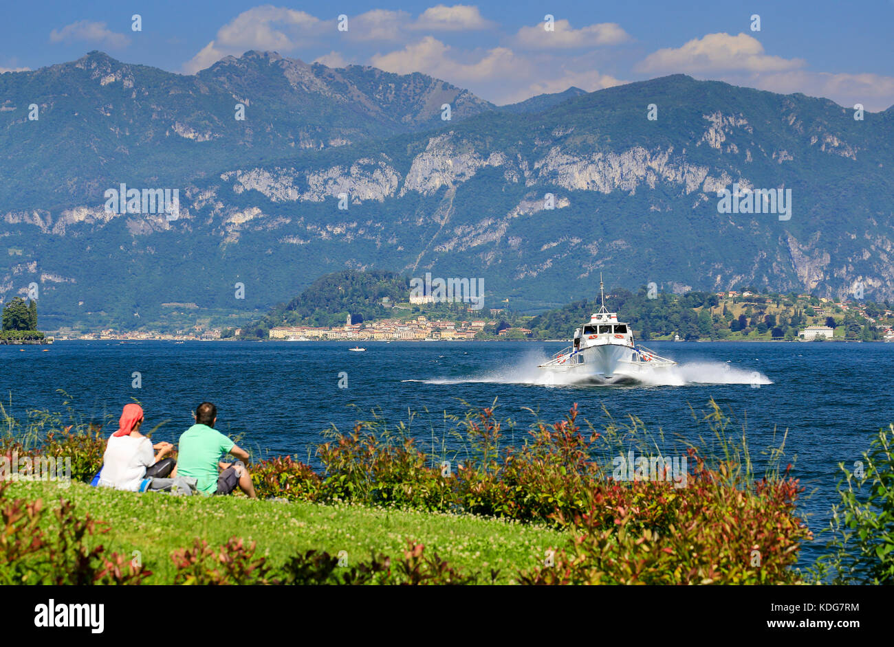 Paar am Ufer beobachten schnelle Tragflügelboot Passagierschiff von Bellagio am Comer See in Italien. Stockfoto