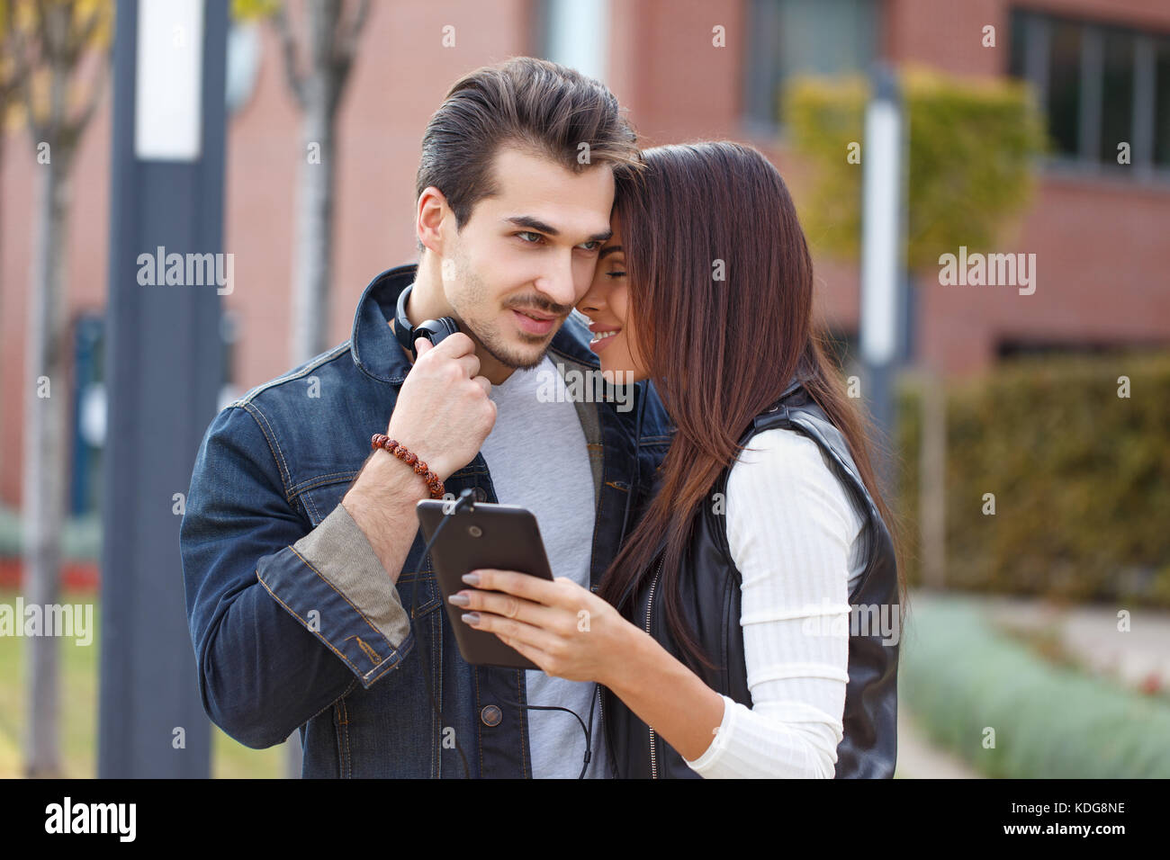 Junge trendige Paar mit Kopfhörern hören zusammen Musik im Park, Herbst, Liebe Stockfoto