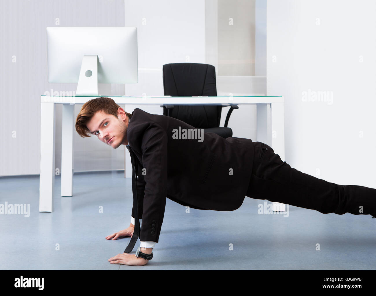Junge Unternehmer pushups Tun an seinem Arbeitsplatz Stockfoto