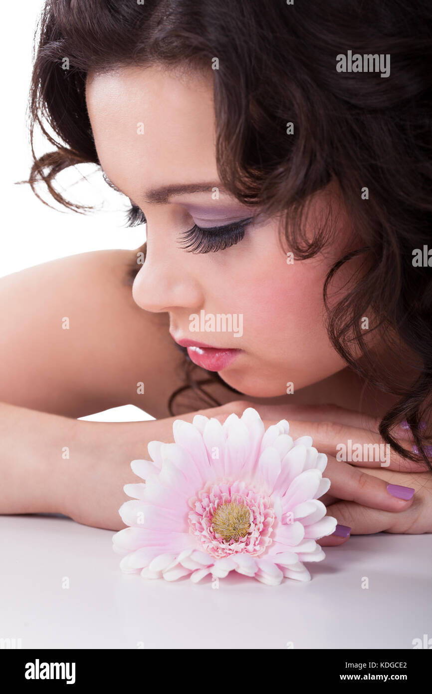 Close-up junge Frau mit Daisy Blume im Haar auf weißem Hintergrund Stockfoto