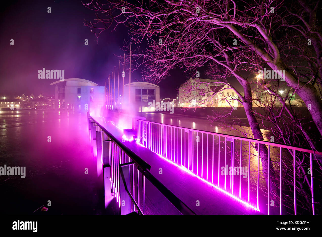 Brücke in Richtung Reykjavik city hall leuchtet rosa im Winter geschossen in der Nacht Stockfoto