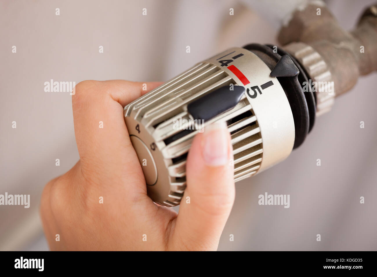 Frau Hand Einstellung der Temperatur mittels Thermostat Stockfoto