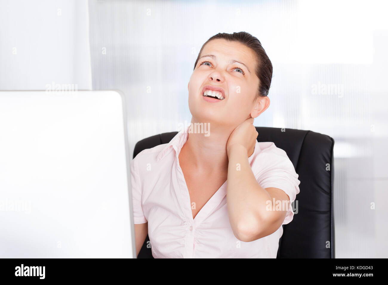 Junge Geschäftsfrau leiden unter Nackenschmerzen in die Vorderseite des Computers Stockfoto