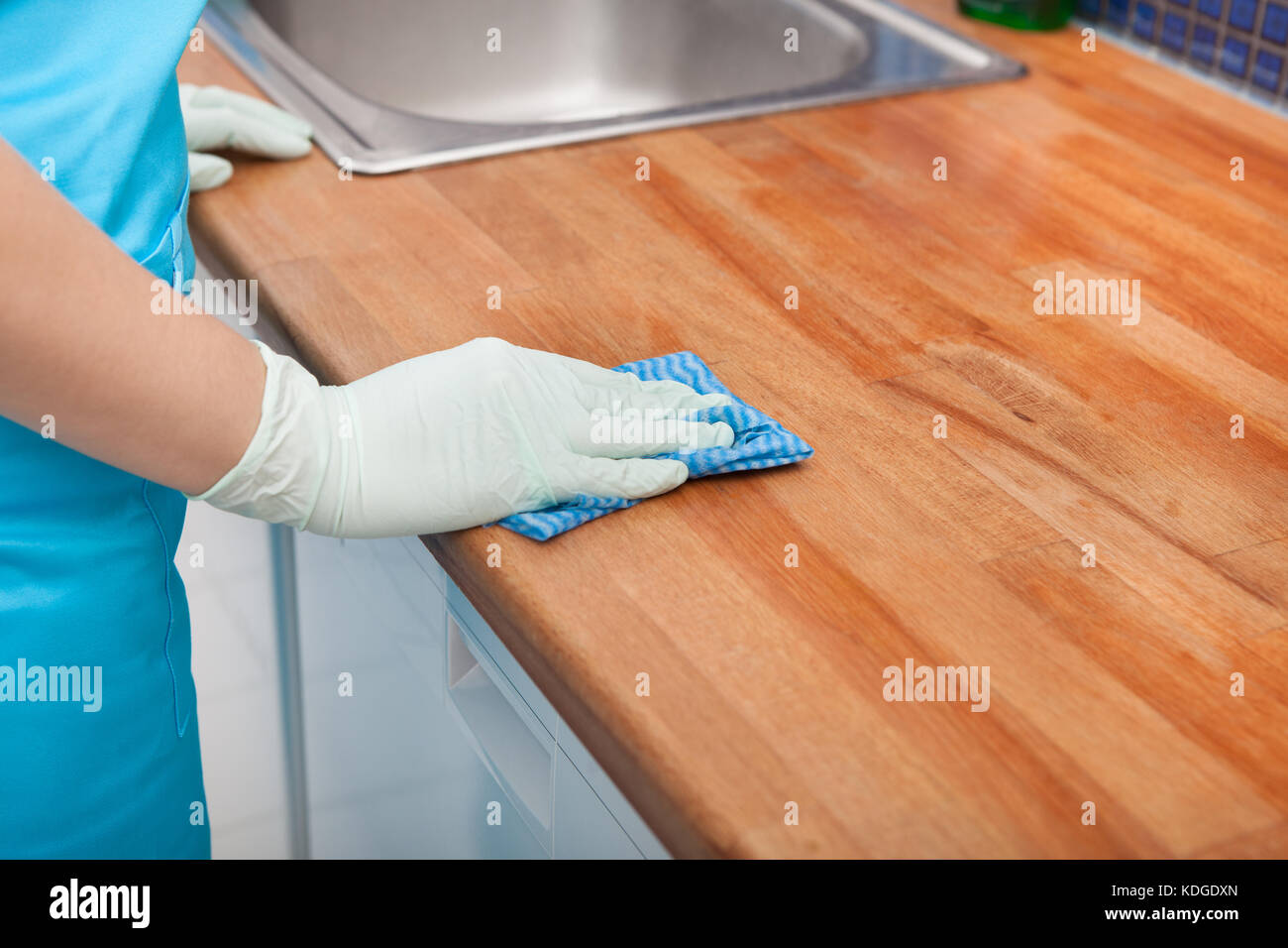 Nahaufnahme der jungen Frau mit Schürze, die Reinigung der Küchenarbeitsplatte Stockfoto