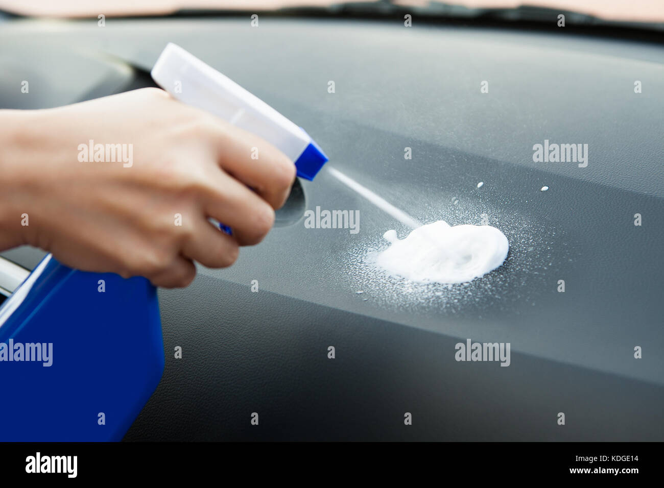 Nahaufnahme von Hand mit Sprühflasche Sprühen auf Auto Stockfoto