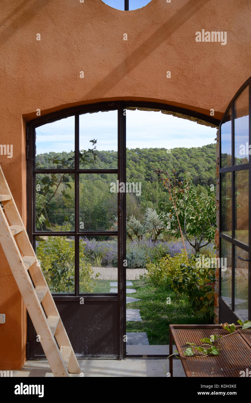 Blick über den Var- oder provenzalischen Wald durch das Gewächshausfenster im Weingut Domaine de Berne, Lorgues, Var, Provence, Frankreich Stockfoto