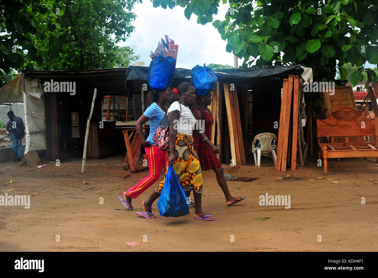 Frauen gehen die blauen Säcke auf ihre Köpfe in Mosambik. Stockfoto