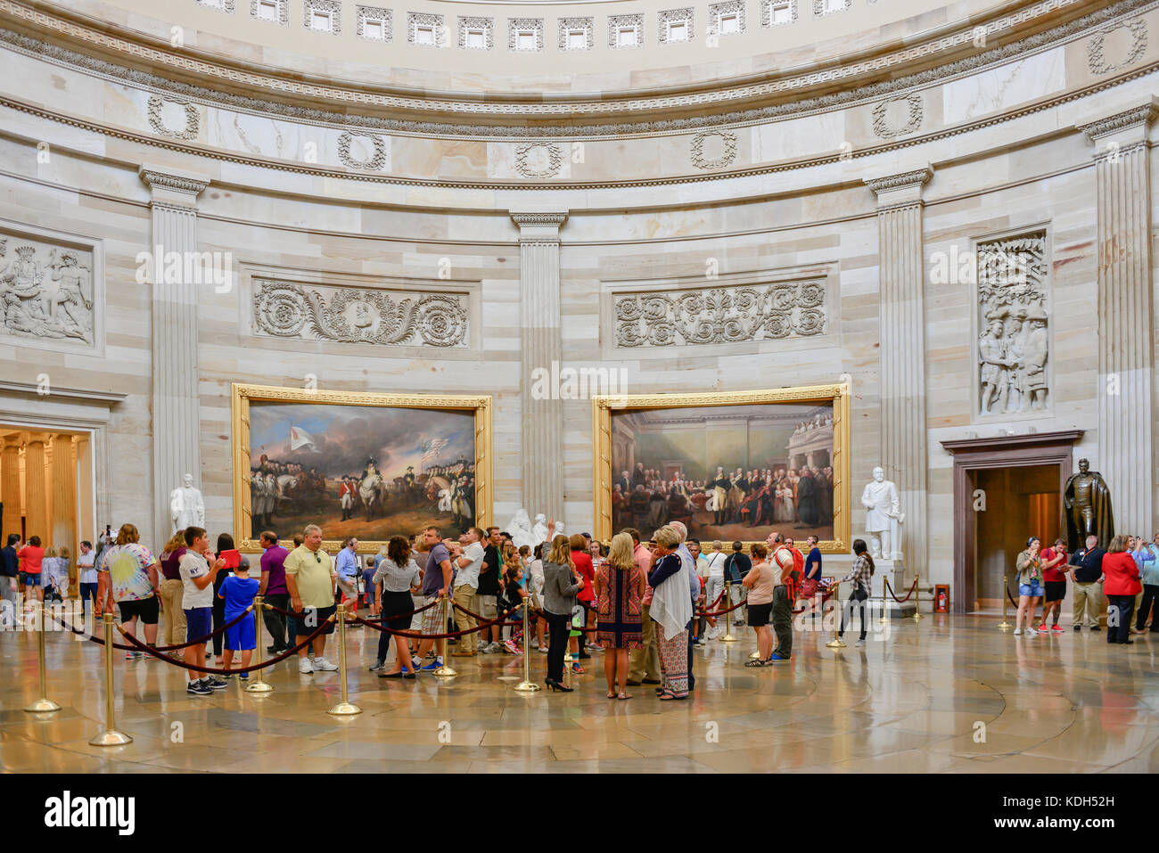 Eine Masse von Menschen, die in der US Capitol Rotunde, bewundern Sie die riesigen Gemälde und Statuen, während sie von Ihrem Reiseleiter in Washington, DC informiert werden Stockfoto