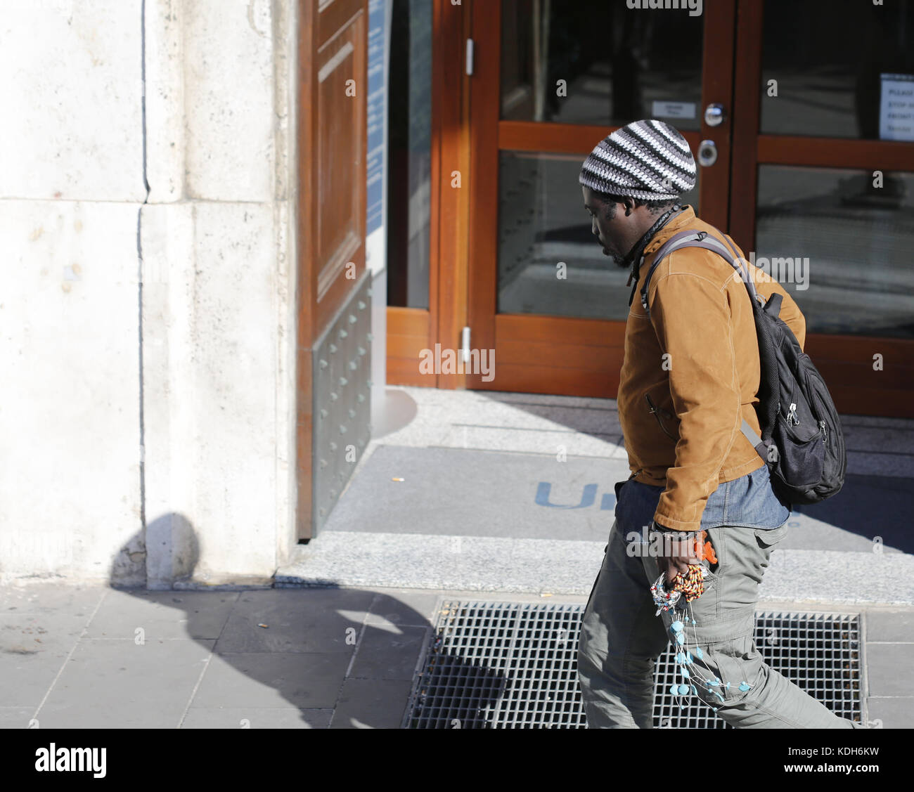 Man Walking entlang einer Straße in Rom. Die Person ist eine Straße Verkäufer. Stockfoto