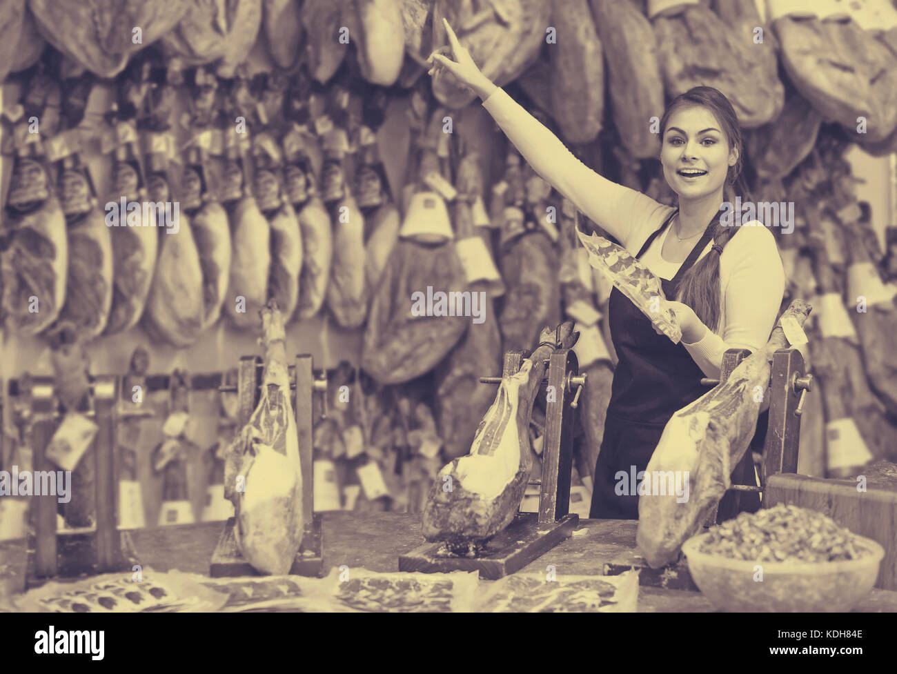 Gerne europäische Frau Metzger mit Speck und Fleisch im Zähler des Store Stockfoto