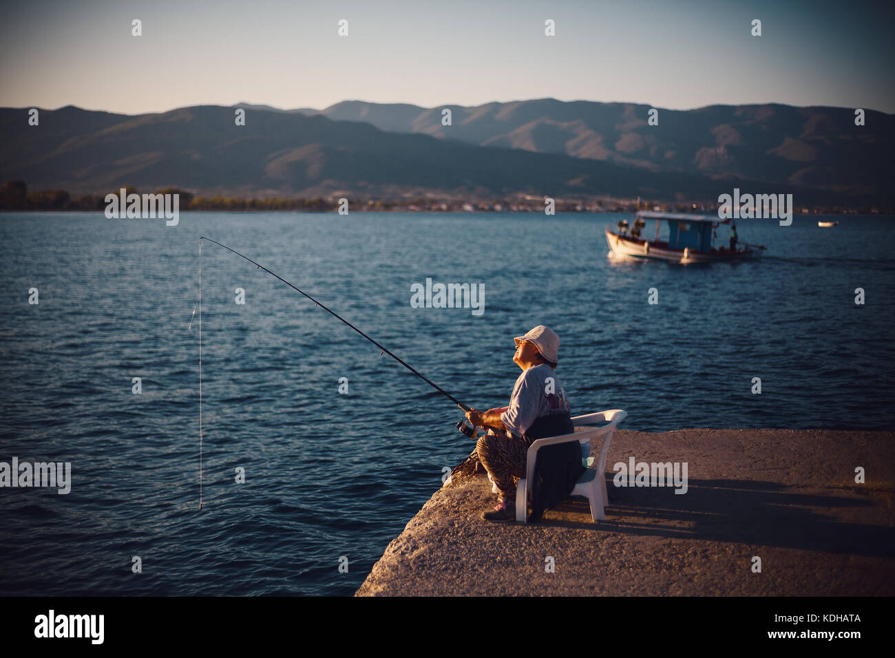 Stavros, Griechenland - September 06, 2017: ältere Frau fischen mit Stick auf Meer Dock. Stockfoto