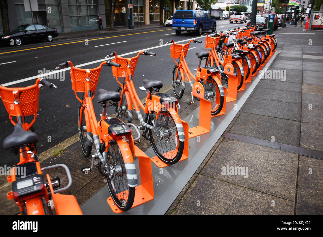 Eine Reihe orangefarbener Leihfahrräder in Portland, Oregon Stockfoto