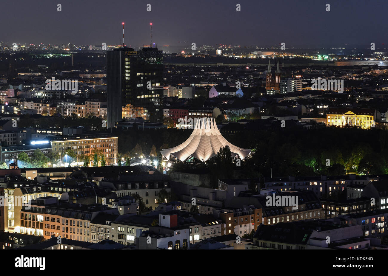 Berlin, Deutschland. Oktober 2017. Das Dach des Tempodroms ist abends hell beleuchtet, im Hintergrund ist der Postbankturm in Berlin, Deutschland, 13. Oktober 2017 zu sehen. Quelle: Paul Zinken/dpa/Alamy Live News Stockfoto