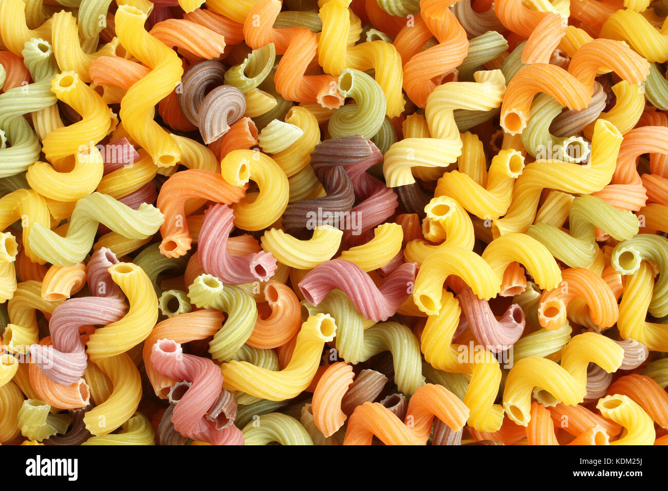 Essen Hintergrund - Ungekocht bunte Cavatappi (Celentani) Hartweizen Nudeln mit Rote Bete, Spinat und Tomaten Stockfoto