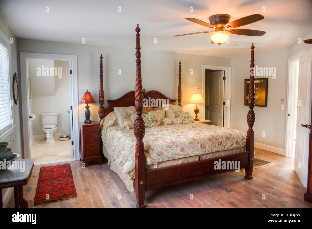 Schlafzimmer mit Himmelbett, Nachttisch, Deckenventilator, Hartholzfußboden  und angrenzendem Bad in einem exklusiven Haus in Vermont, USA  Stockfotografie - Alamy