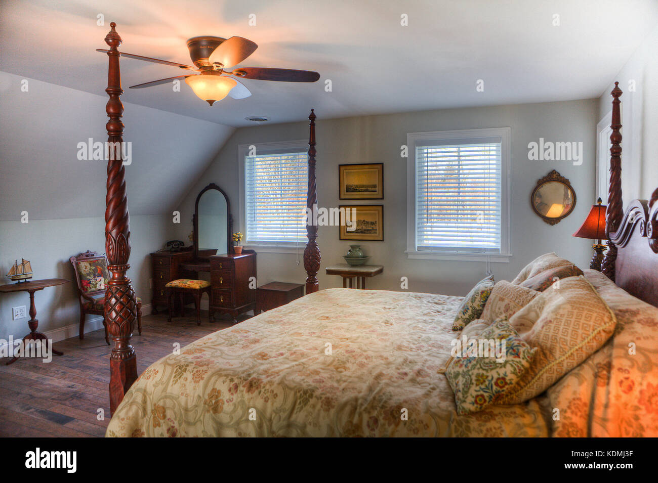 Schlafzimmer mit Himmelbett, Nachttisch, Deckenventilator, Hartholzfußboden und angrenzendem Bad in einem exklusiven Haus in Vermont, USA. Stockfoto