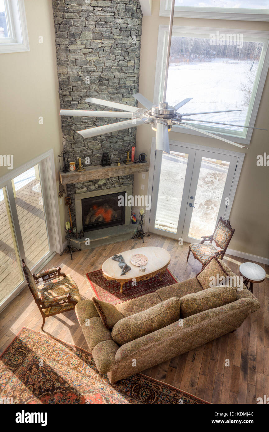 Modernes, schickes Wohnzimmer mit angrenzender Küche, Esszimmer und Kamin aus Stein in Vermont, USA. Stockfoto