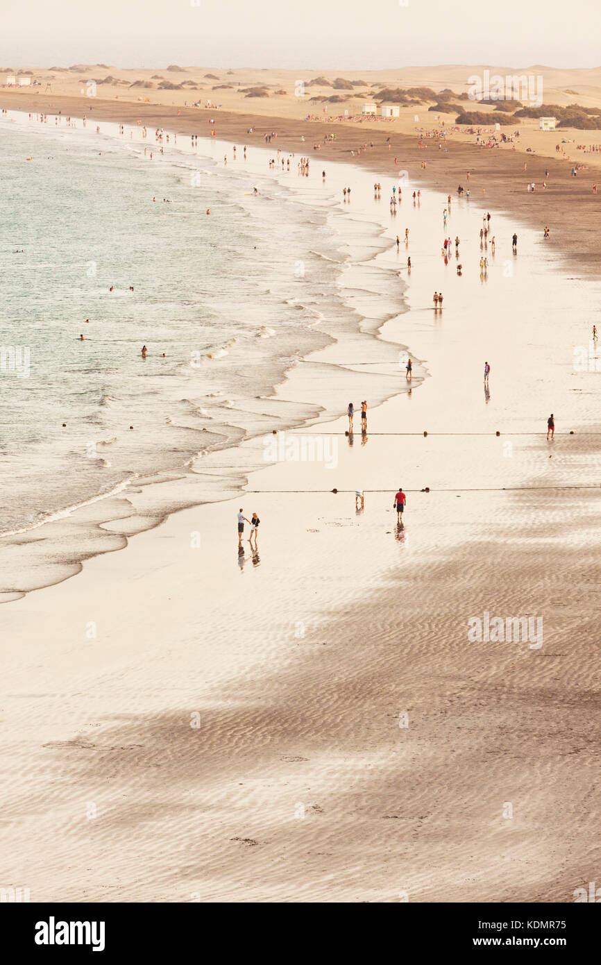 High key Bild des Menschen am Strand von Playa del Inglés, gran canaria Dünen von Maspalomas im Hintergrund. Stockfoto