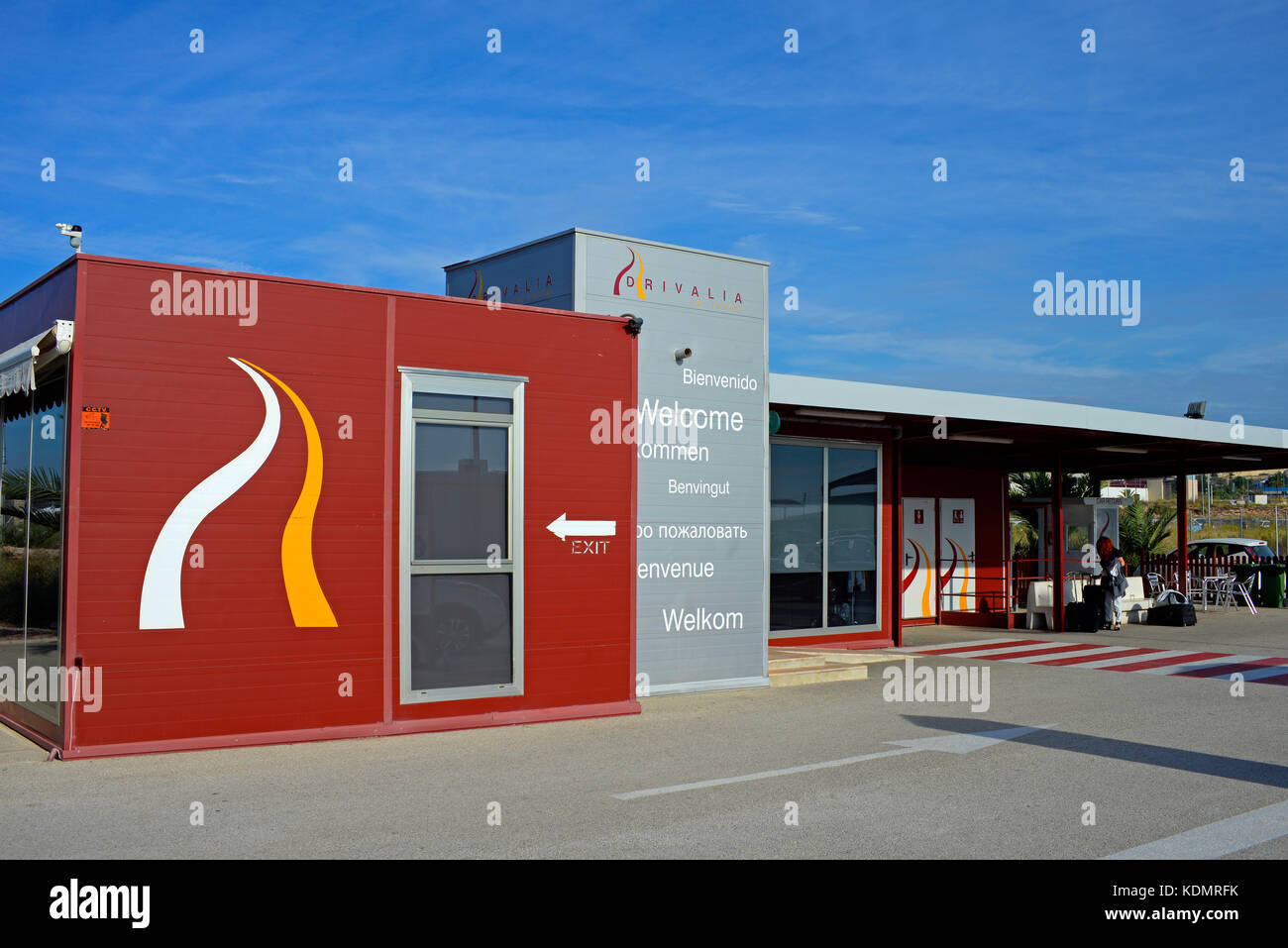 Drivalia Autovermietung am Flughafen Alicante Spanien. Fahrzeugmiete. Willkommen in verschiedenen Sprachen. Kundentoiletten. Wartebereich. Blauer Himmel Stockfoto