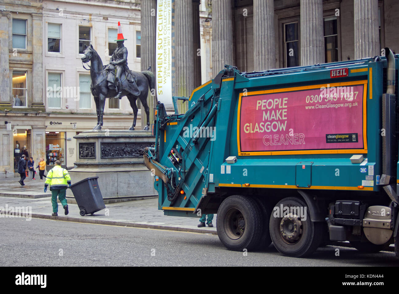 Dustcart binmen mit an der Kegelspitze Mann Herzog von Wellington statue Gallery of Modern Art, Royal Exchange Square, Glasgow machen cleaner Logo Stockfoto