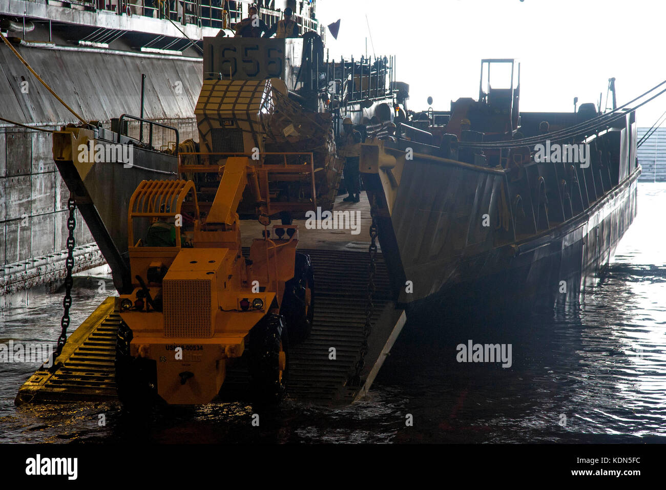 Segler laden Sie einen Generator auf eine Landing Craft Utility (LCU) Stockfoto