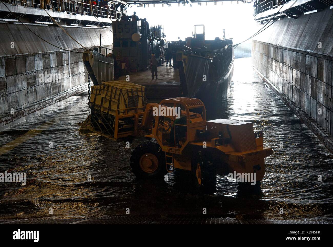 Segler laden Sie einen Generator auf eine Landing Craft Utility (LCU) Stockfoto