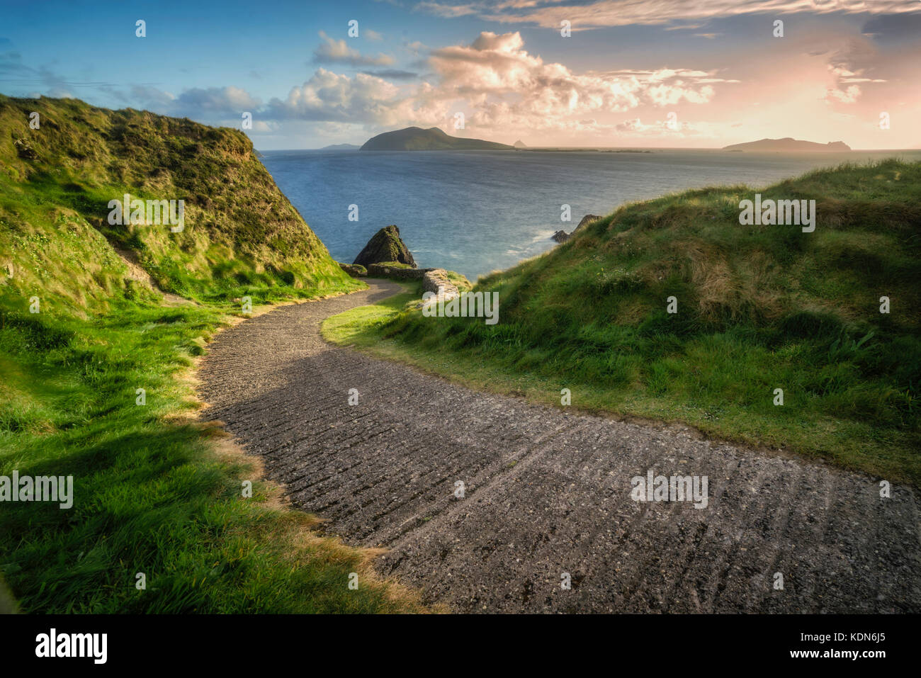 Straße Pier mit offshore Felsen in Dunquin und kurvenreiche Straße. County Kerry, Irland Stockfoto