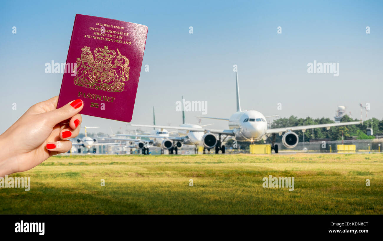 Halten eines britischen Reisepass, bei der die Zeile der Flugzeuge rollen - Travel Concept Stockfoto