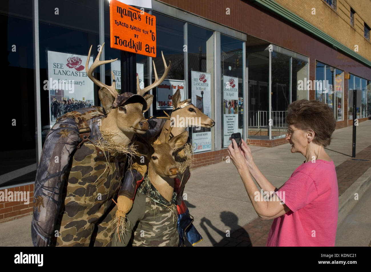 Halloween street Anzeige, USA. Display zeigt Kaukasischen senior Frau Snapshot wird der Rotwild Jäger für alle Hallow Eve. Stockfoto