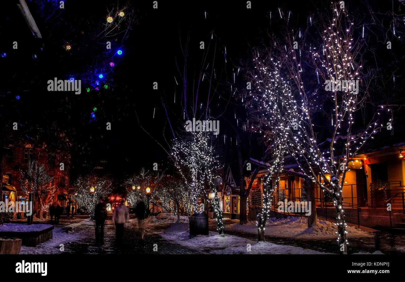Night Street in der Innenstadt von Aspen, Colorado, Mit Weihnachtsbeleuchtung und Dekoration eingerichtet. Unscharfe Figuren von Menschen zu Fuß entlang der Straße; Usa Stockfoto