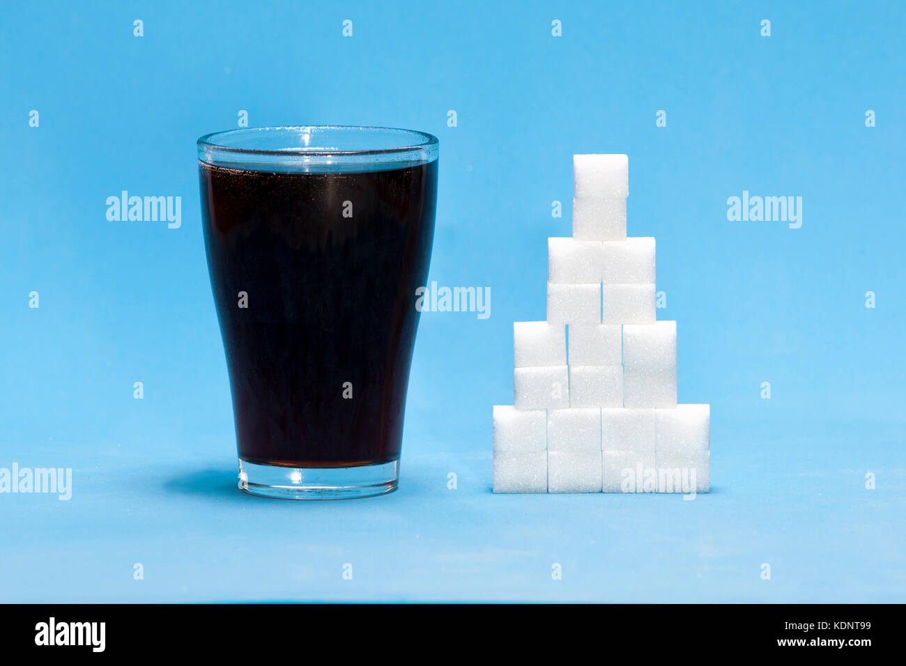 Würfelzucker mit Cola als Konzept von zu viel Zucker in das Getränk Stockfoto