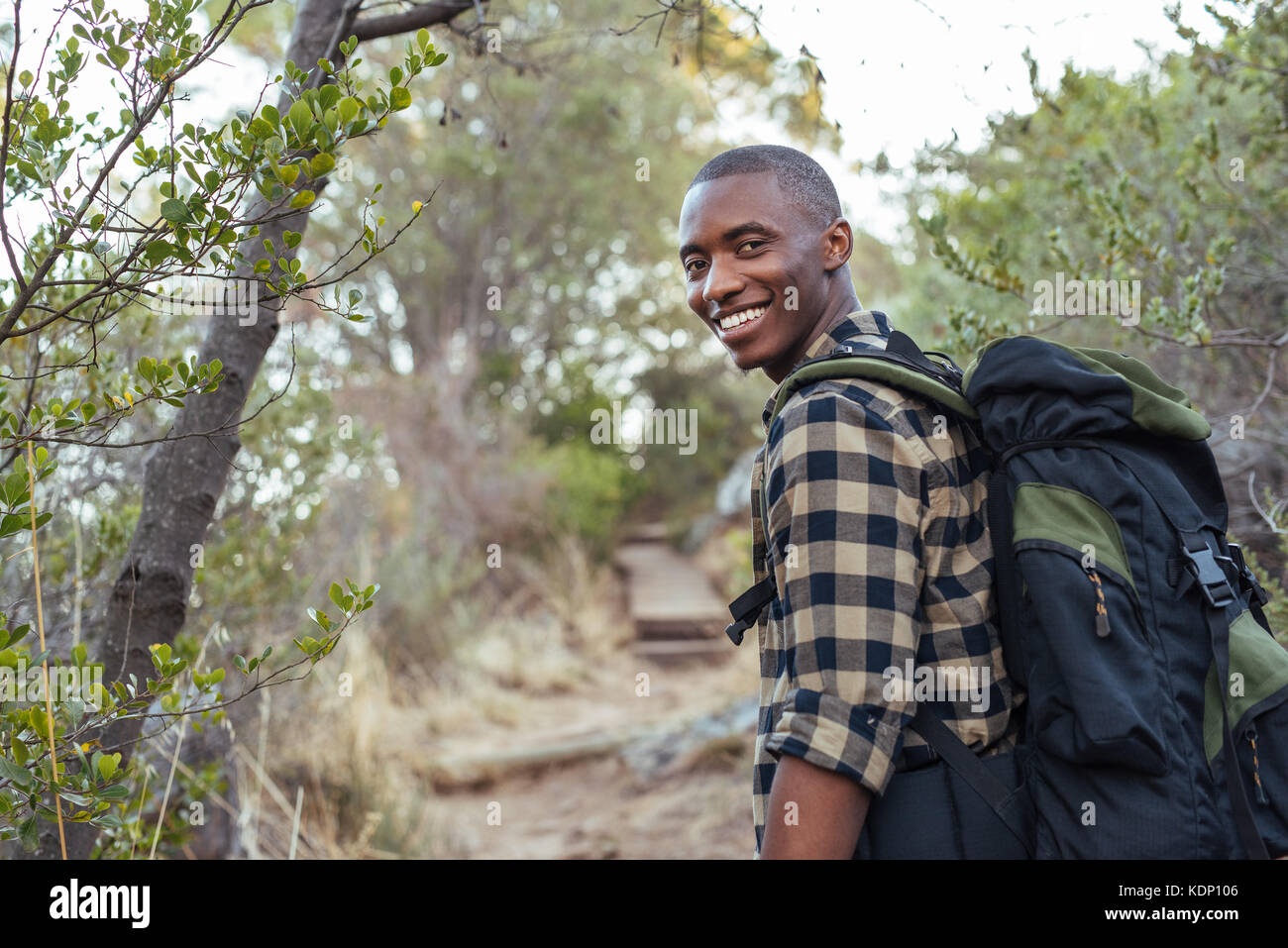 Lächelnden jungen afrikanischen Mann Wandern in den Hügeln Stockfoto
