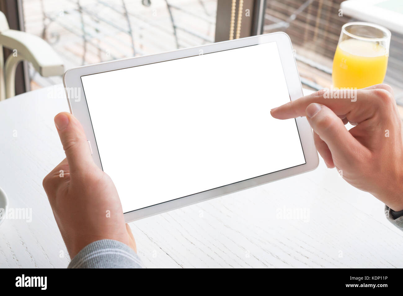 Berühren Sie das Tablet mit der rechten Hand. Tablet mit isoliertem Bildschirm für Mockup. Horizontale Position. Stockfoto