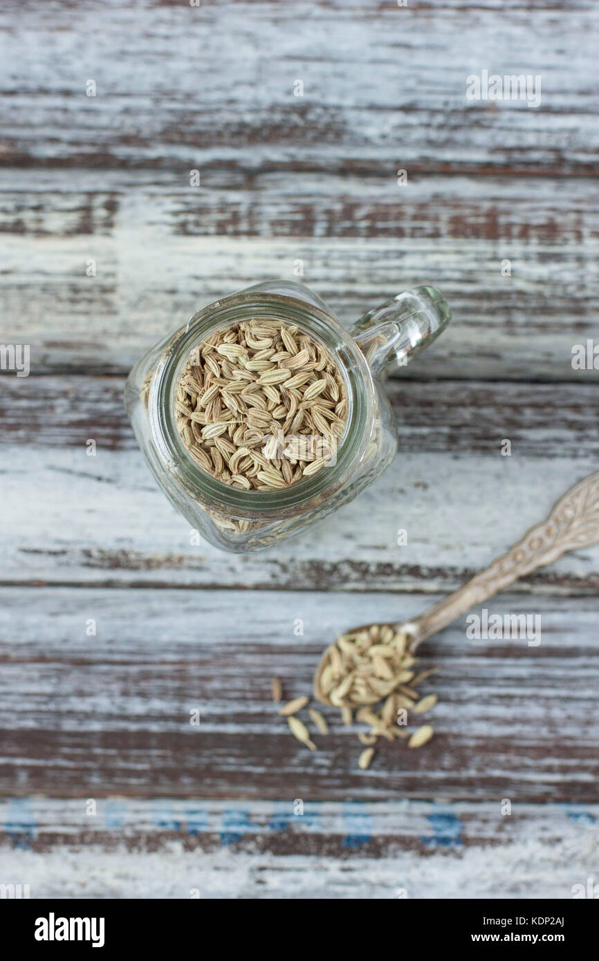Fenchel Samen in Glas und Silber Löffel auf rustikalen Hintergrund, Areal anzeigen Stockfoto
