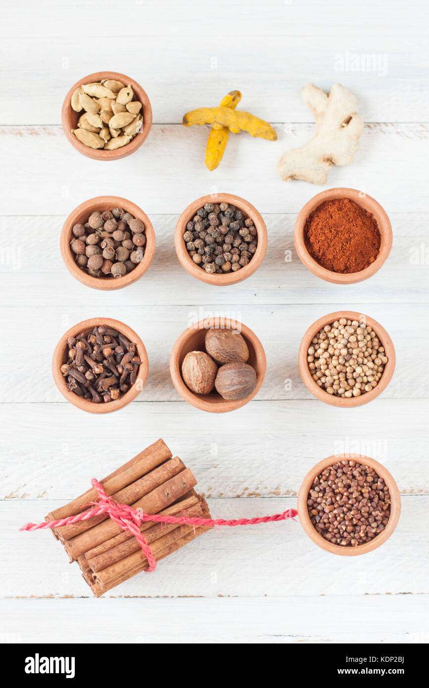 Gewürze für Ras-el-Hanout, marokkanische Gewürzmischung, alle in Ton getrennt Schüsseln auf rustikalen weißlich Hintergrund Stockfoto