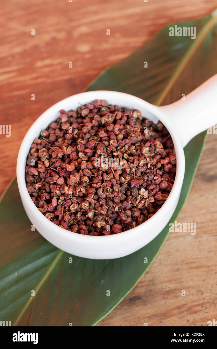 Sichuan Pfeffer auf Weiß Schüssel über grünes Blatt Stockfoto